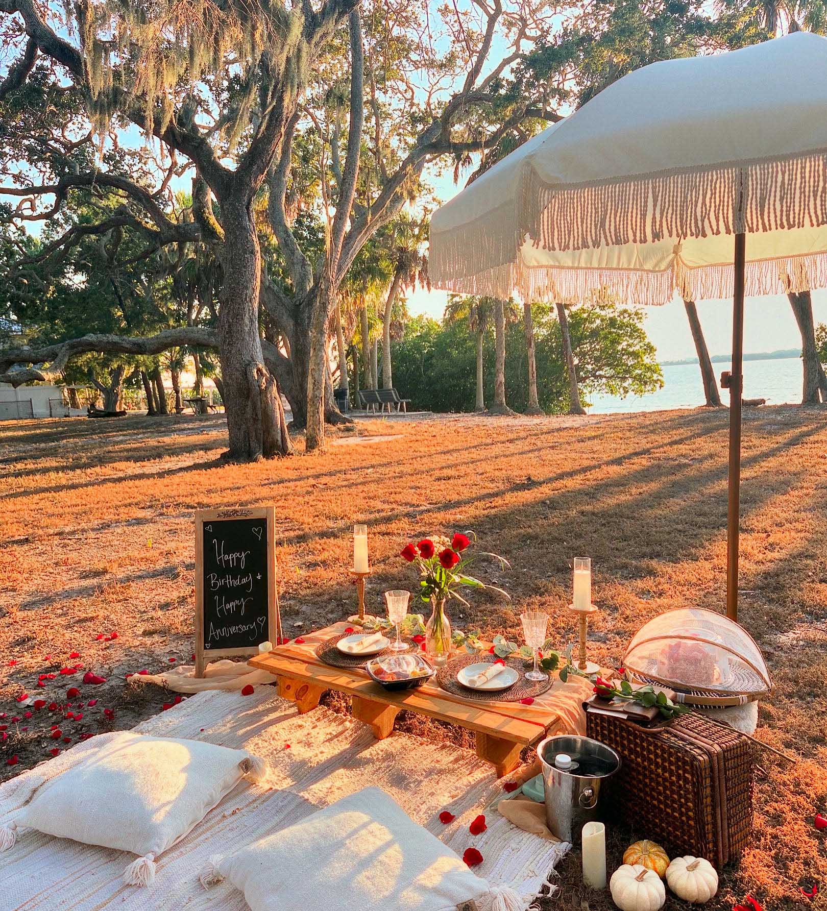 A picnic table with an umbrella is set up on a grassy area, inviting relaxation and outdoor dining.