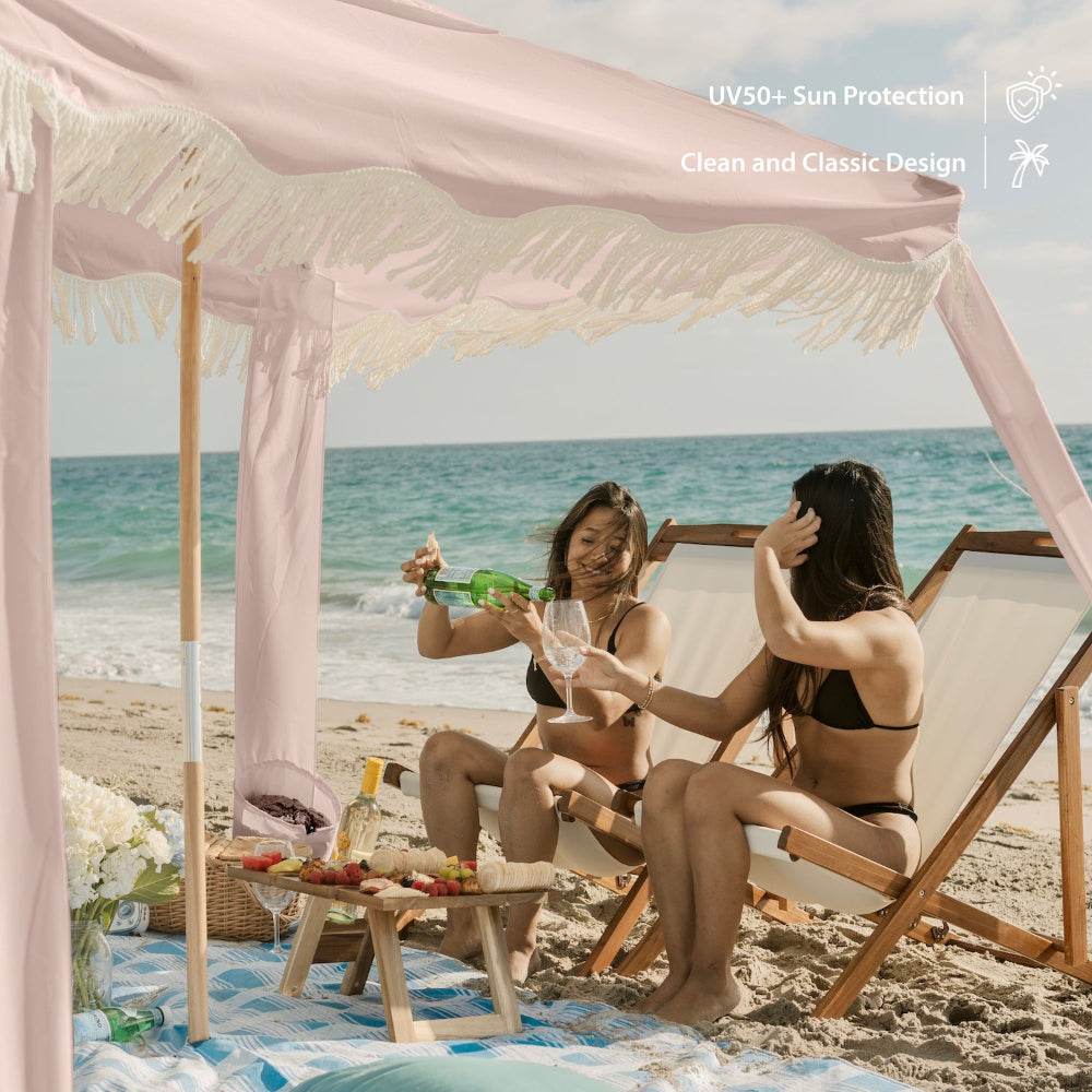 Two women sitting under AMMSUN 7ftx7ft fringe coolcabana beach tent for beach shade with fringe