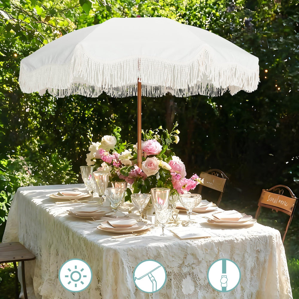 Outdoor table setting with AMMSUN 6.5ft white fringe umbrella outdoor patio, flowers, under a tree.
