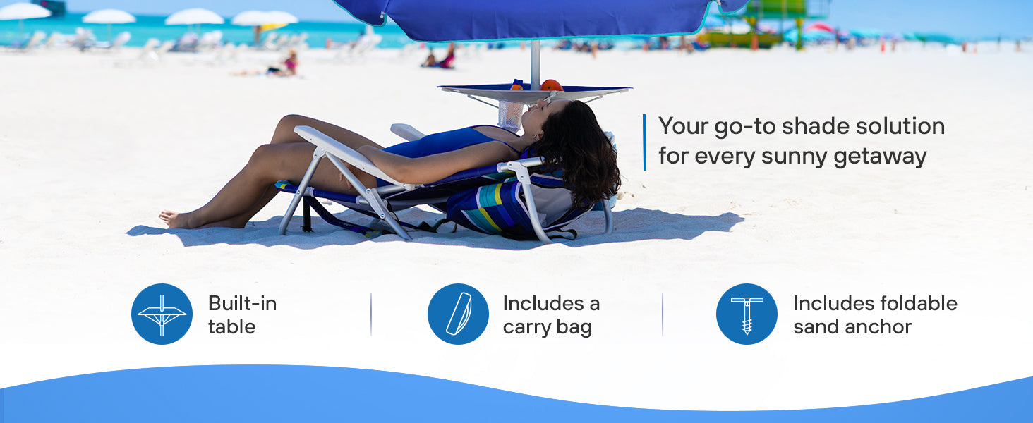 A woman relaxes on the beach, seated under AMMSUN 7ft blue heavy duty umbrella with built-in table and sand anchor
