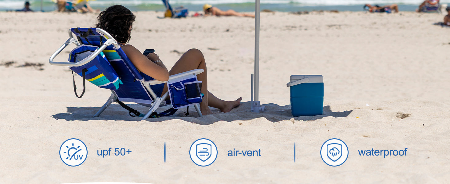A woman sitting under AMMSUN 7.5ft multicolor blue portable umbrella with sand anchor on beach