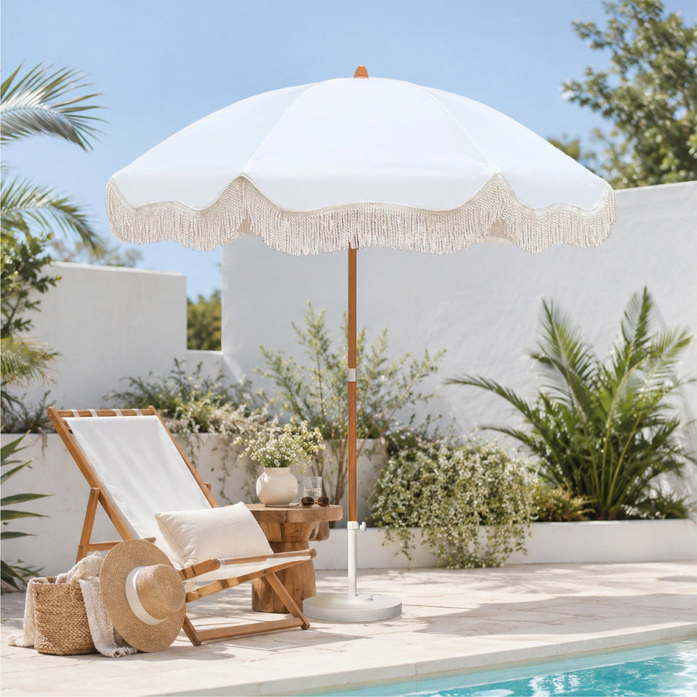Ammsun 6.5ft white patio umbrella with Wood-inspired Finish Steel Pole and fringe sets up next to a clear swimming pool.