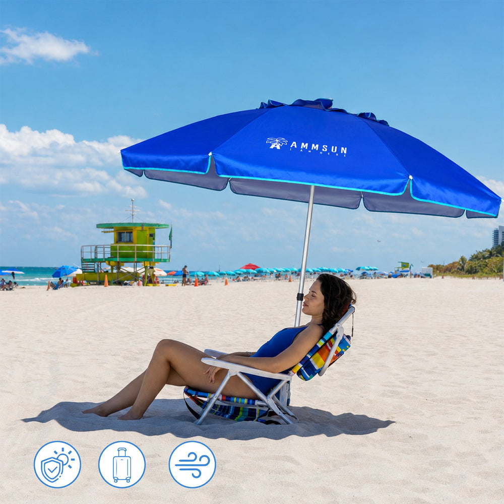 A woman relaxes in a beach chair under an Ammsun blue 6.5ft folded travel beach umbrella for wind resistant beach umbrella