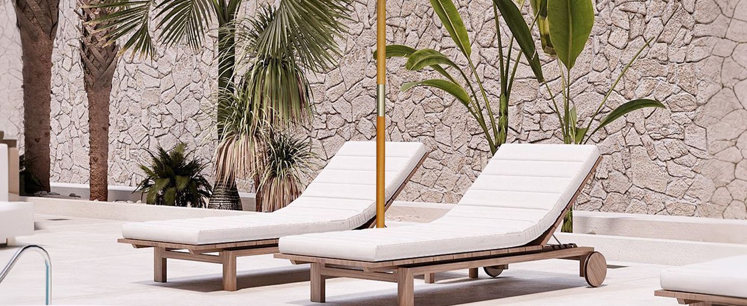 Two white lounge chairs on a patio with stone wall and palm trees in the background