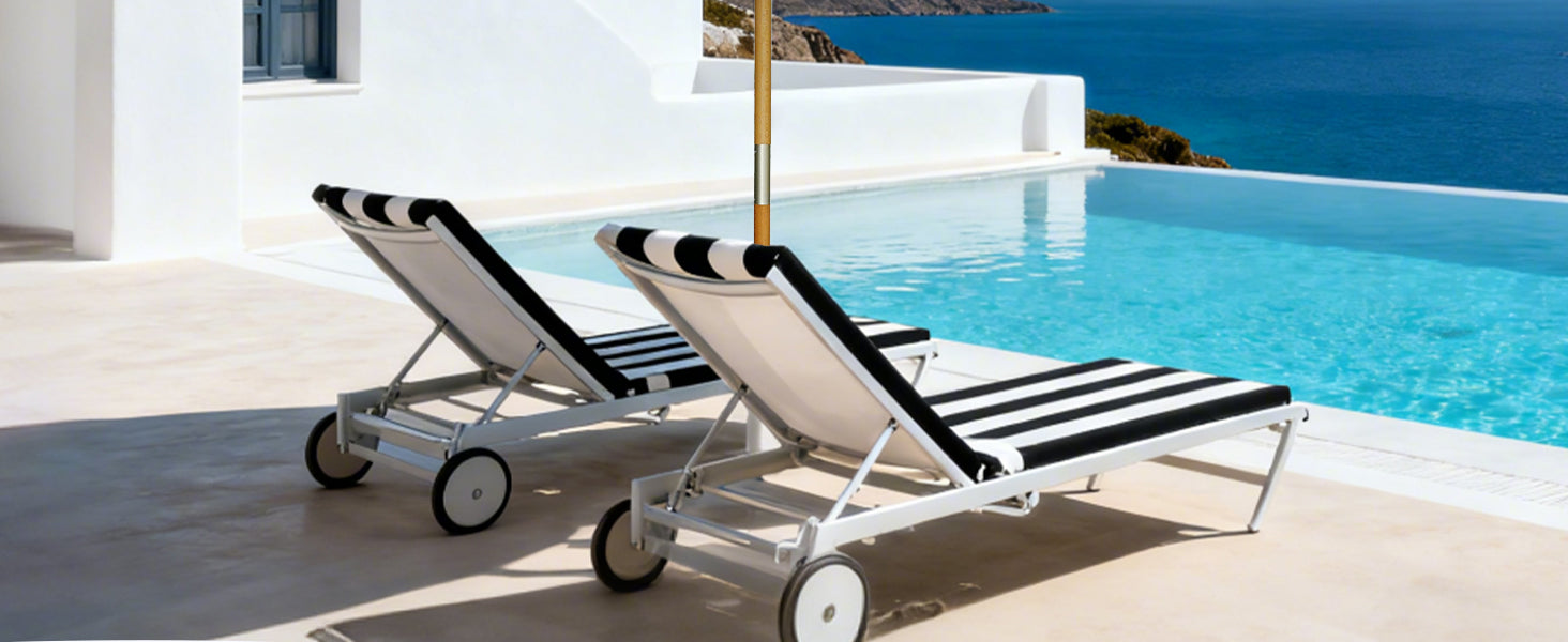 Two black and white striped lounge chairs by a pool with a scenic background.