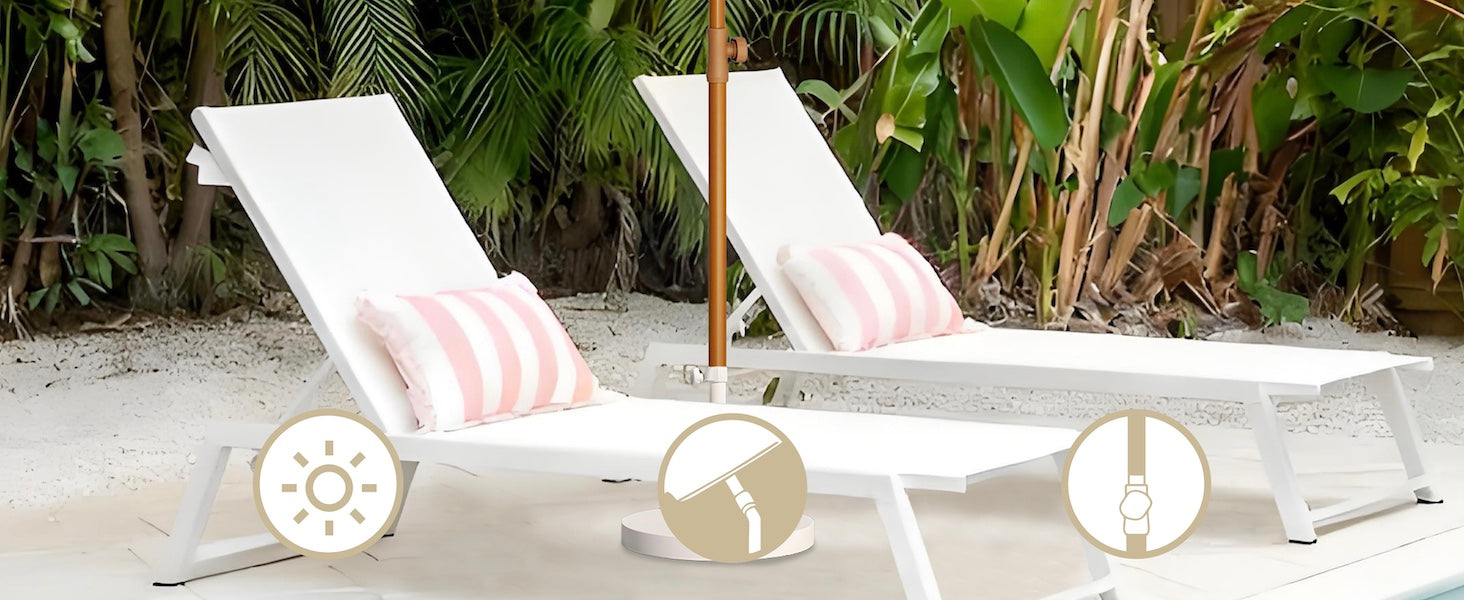 Two white lounge chairs with striped cushions on a sandy beach with palm trees in the background.