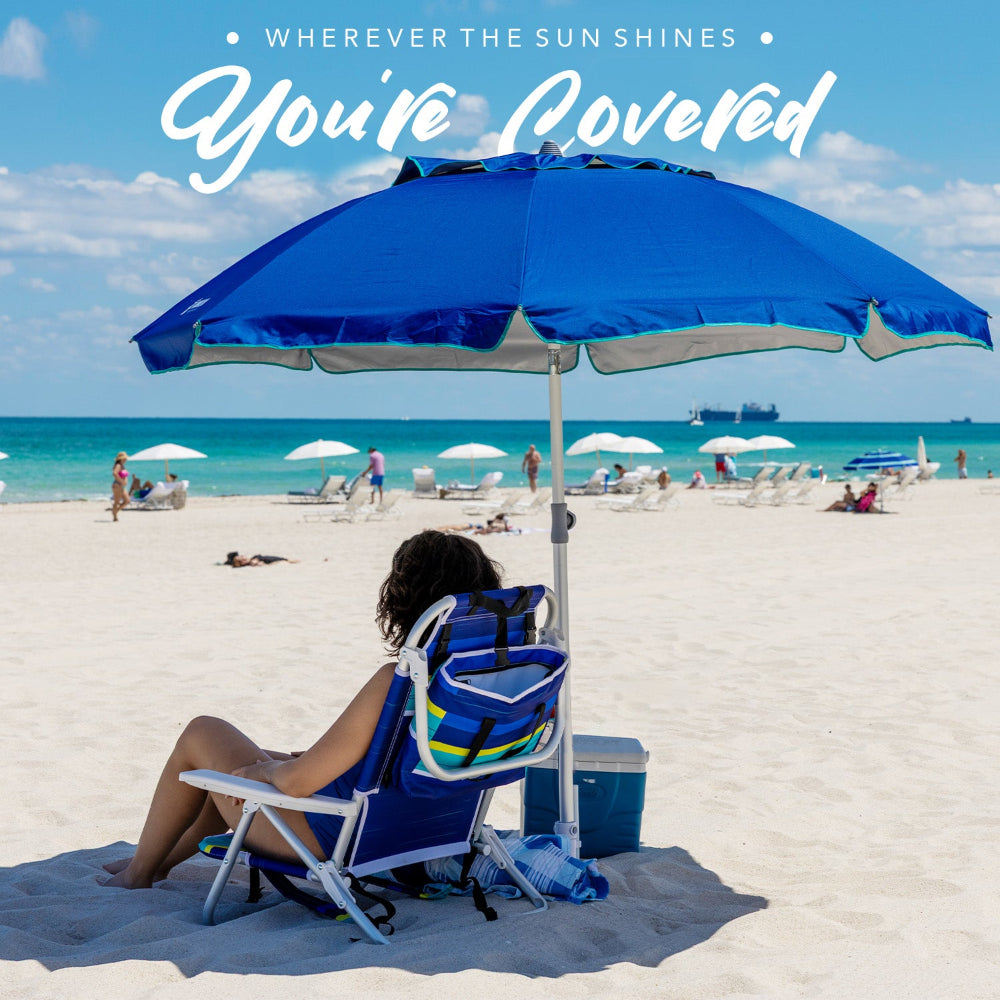A woman relaxes on the beach under an AMMSUN 7ft blue beach large umbrellas with sand anchor