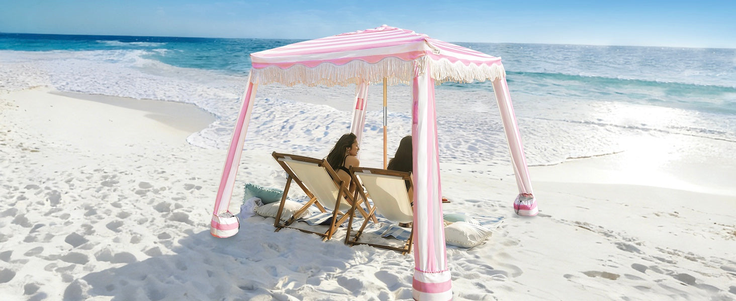 Two women sitting under and AMMSUN 6'x6' pink stripe beach canopy tent sun shade with fringe