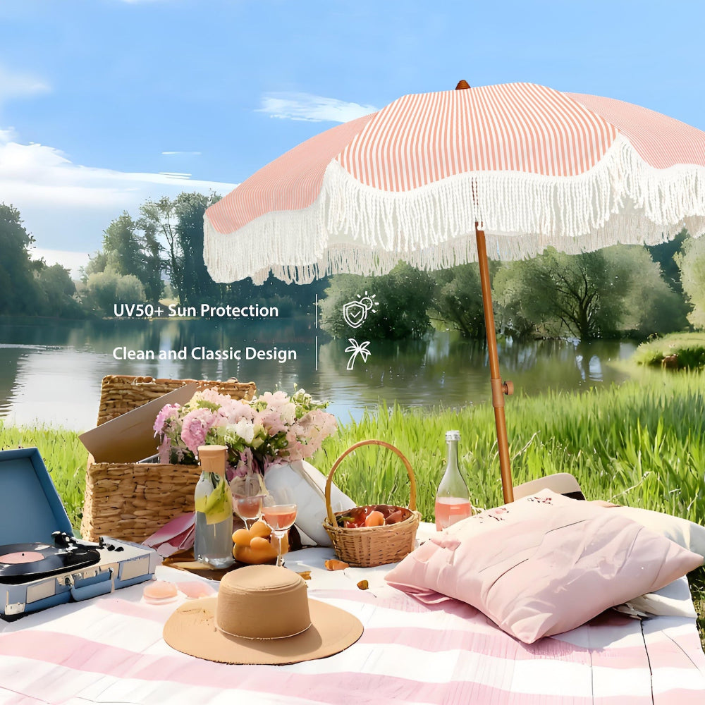 An AMMSUN pink striped large umbrella outdoor patio backyard umbrella, tableware, and flowers by a lake.