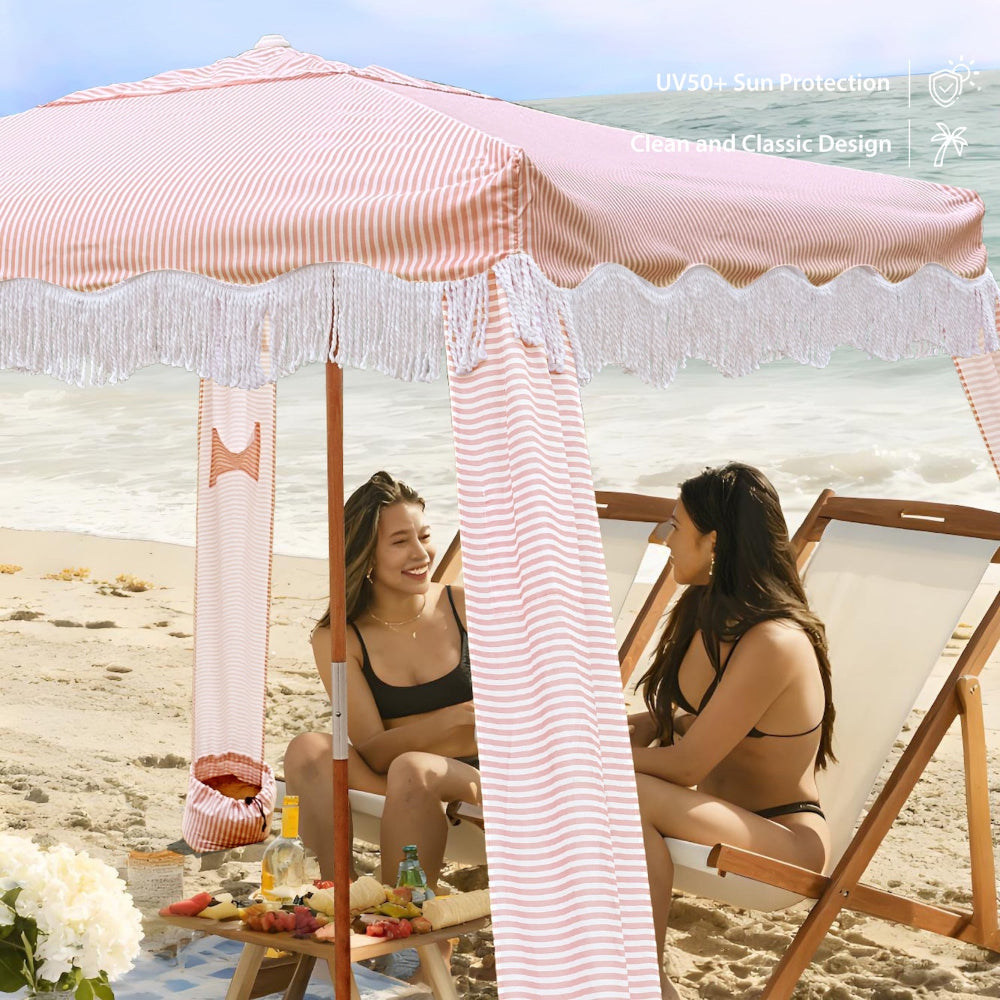 Two women sitting under AMMSUN 7ftx7ft pink stripes fringe outdoor cabana beach tent for beach shade with fringe