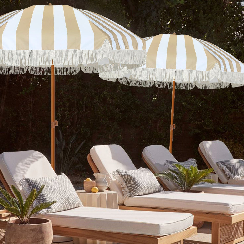 Two AMMSUN boho umbrella fringe decorative umbrella for outdoor over lounge chairs with cushions and plants outdoor.