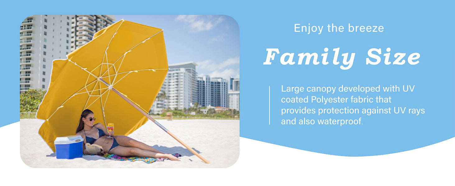 A woman lying under an AMMSUN yellow heavy duty patio umbrella on beach