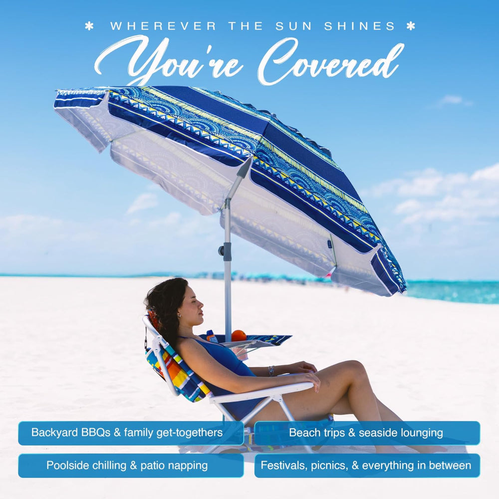 A woman relaxes under AMMSUN 7FT haute stripes travel beach umbrella with sand anchor and table