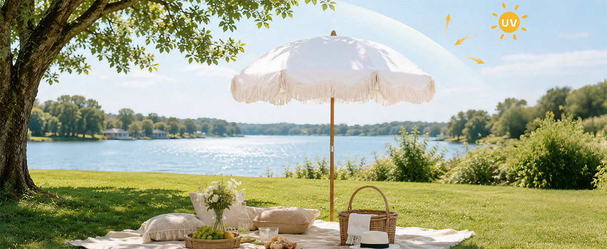 Ammsun 6.5ft white fringe patio umbrellas with wood-inspired steel pole stands on a grassy lakeside lawn for picnic