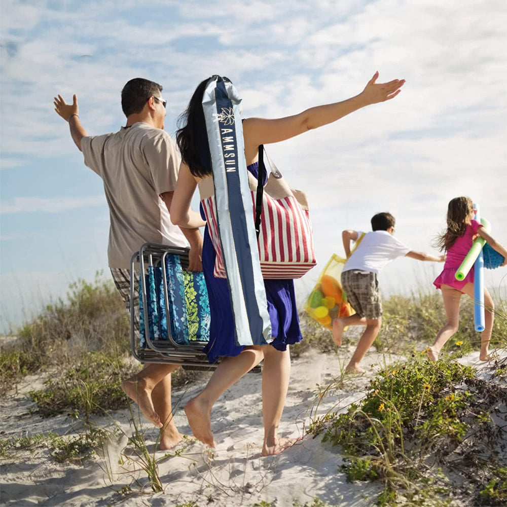 Family walking on a sandy path towards the ocean with AMMSUN 6.5ft portable umbrella for travel with base in carry bag on mom's shoulder