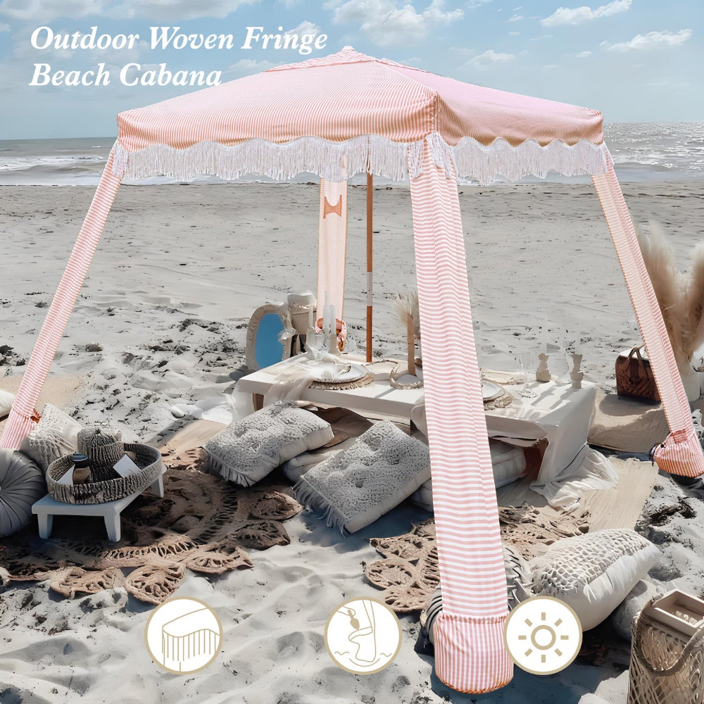 An AMMSUN 7ftx7ft pink stripes boho canopy beach tent with white fringe on beach