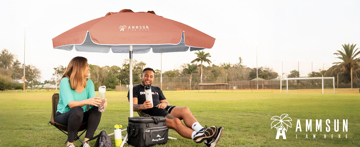 Two people sitting under a lAMMSUN 6.5ft sports umbrella lightweight portable umbrella  on grass