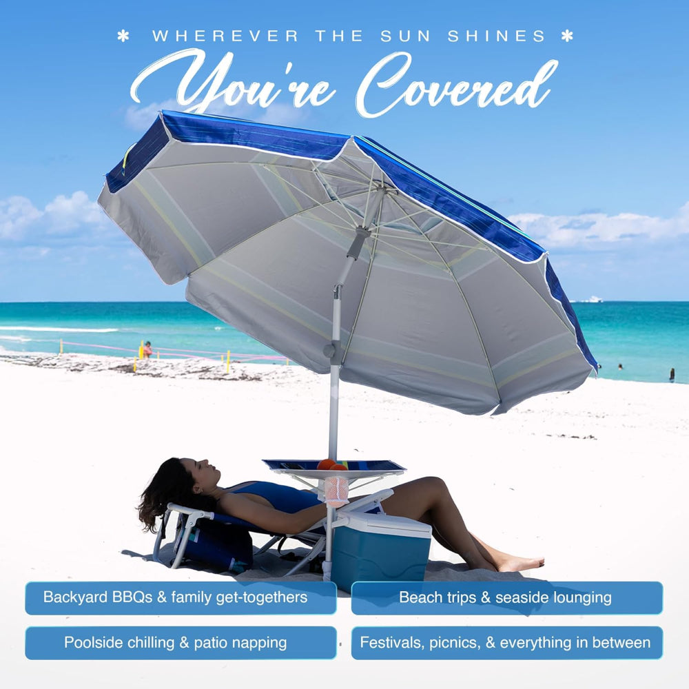 A woman lying under an AMMSUN 7ft blue stripes umbrella for beach with stand and table tray
