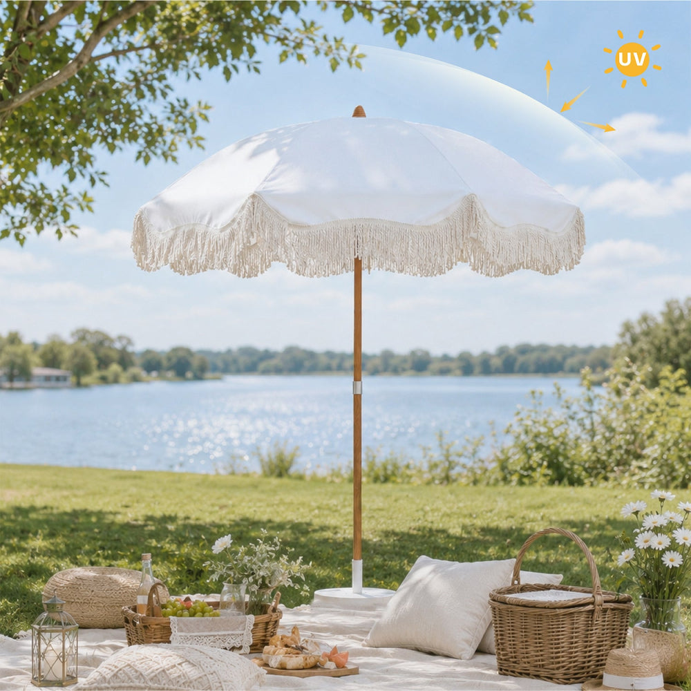 AMMSUN 6.5ft white outdoor picnic fringe umbrella with a picnic basket, surrounded by green grass