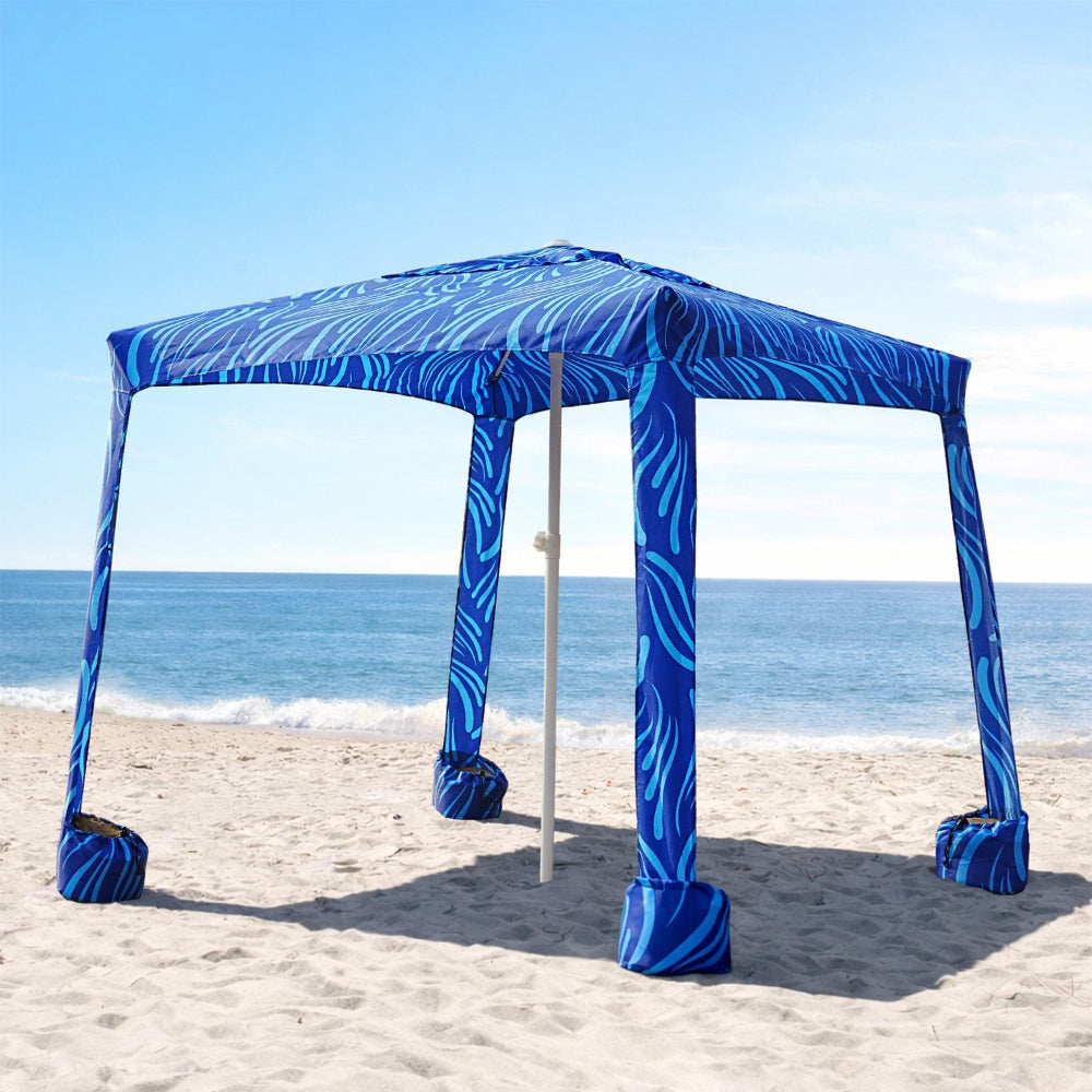 An AMMSUN 6.2'×6.2' beach shade canopy wind sail with privacy wall for beach cabana rests on a sandy beach