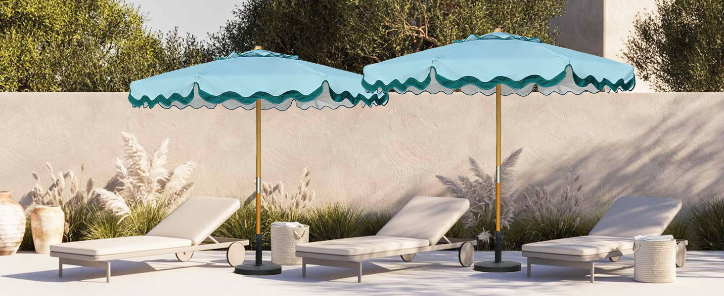 Two market umbrella for outdoor patio umbrella with wavy edges over lounge chairs on a patio.