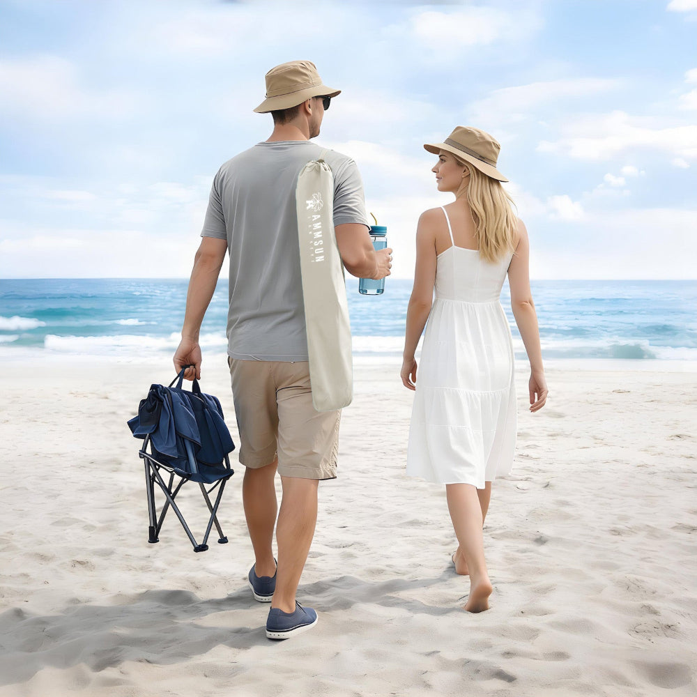 A man and woman stroll along the beach, carrying a beige bag for AMMSUN beach chair umbrella with clamp