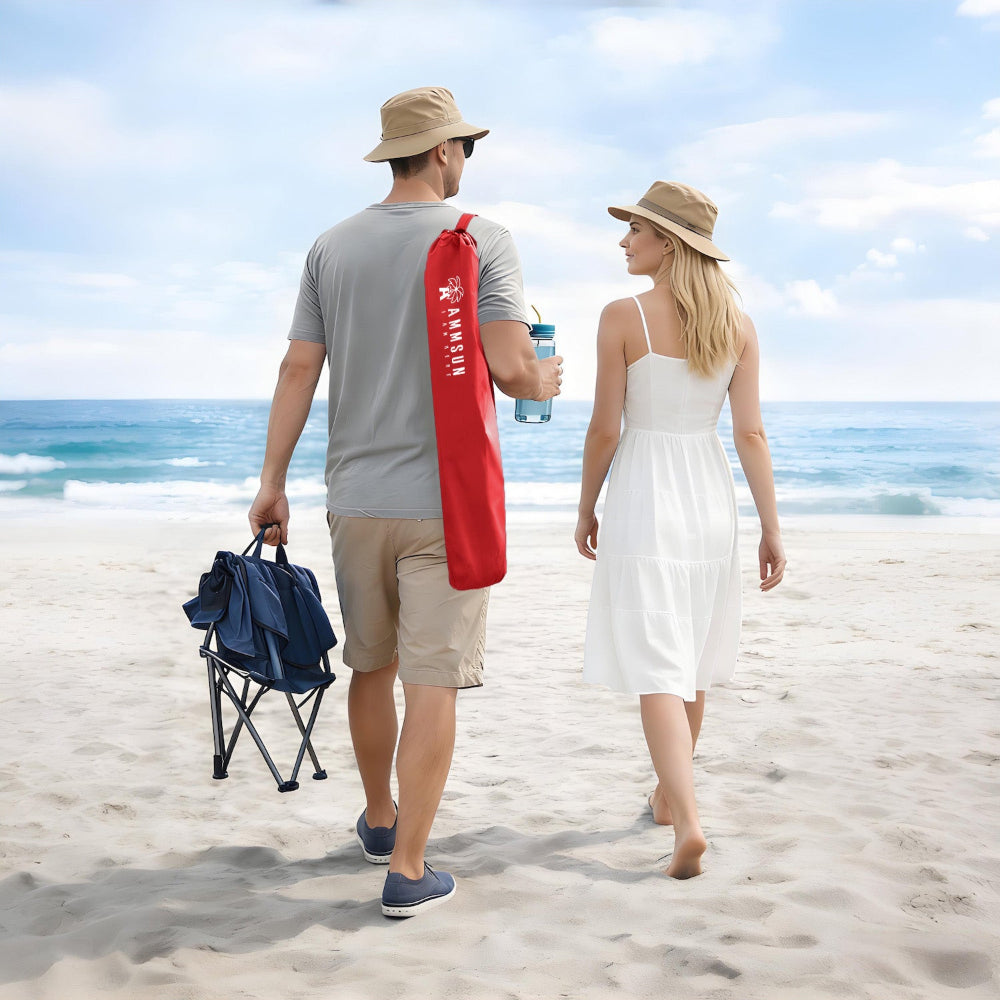 Two people stroll along the beach, carrying a red bag for AMMSUN wheelchair umbrellas with clamp for beach chair