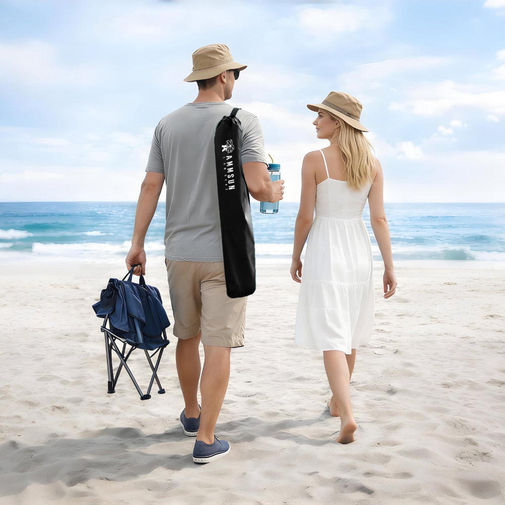Two people stroll along the beach, carrying a black bag for AMMSUN wheelchair umbrellas with clamp for beach chair