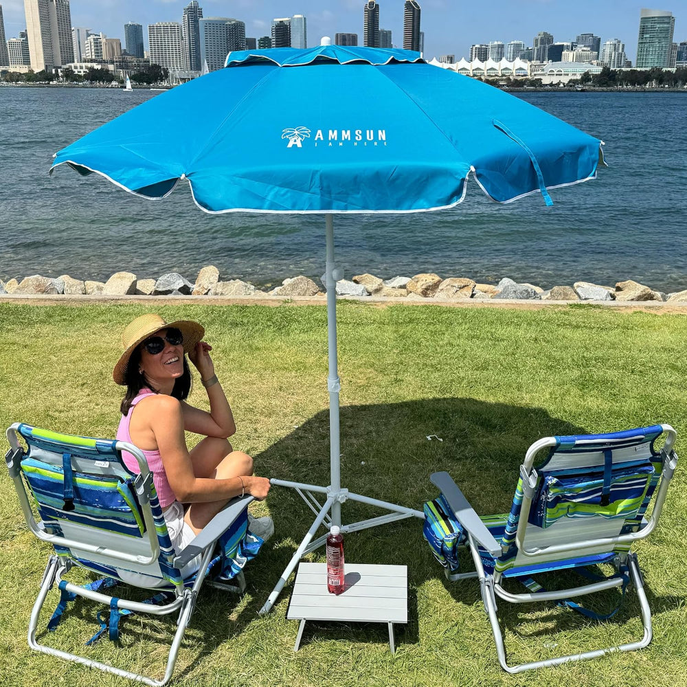 A woman sitting under an AMMSUN sky blue portable outdoor umbrellas with camping tripod for outdoor shades by lake