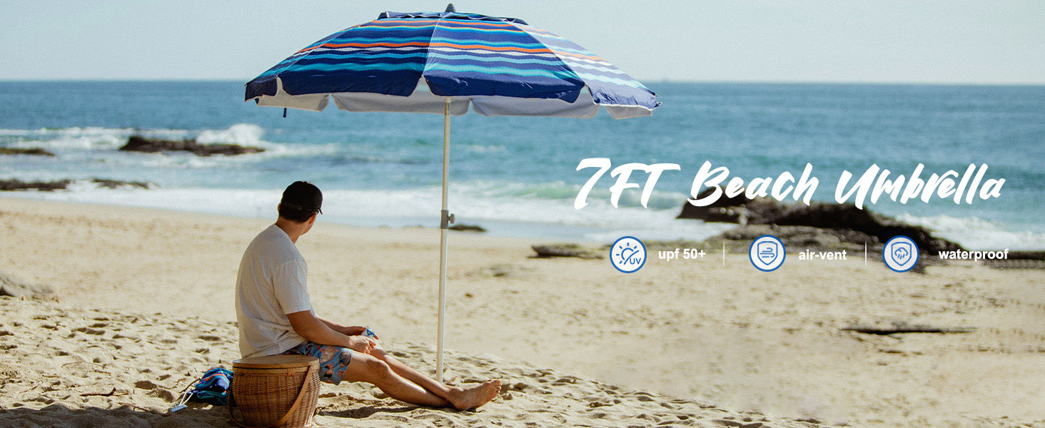 A man relaxes on the beach, seated under AMMSUN 7ft multicolor stripes travel beach umbrella with sand anchor