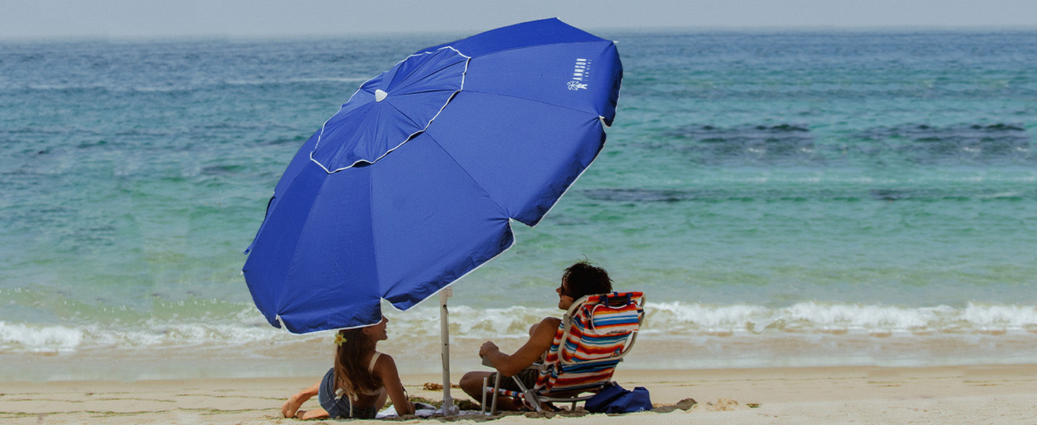 Two people joyfully playing with AMMSUN 8ft blue beach umbrellas for sand heavy duty wind portable with sand anchor