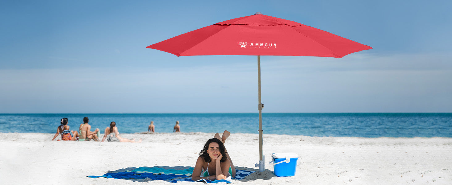 A woman enjoying shade umder an AMMSUN 8ft red heavy duty beach umbrellas for sand, enjoying a tranquil moment on the beach